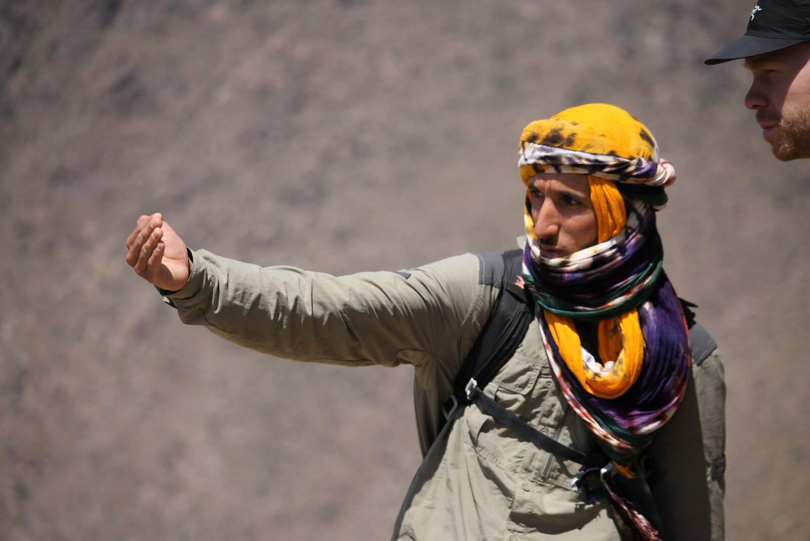 Radouane explaining the High Atlas landscape during a mountain trek in Morocco